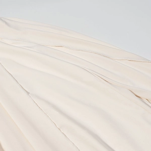 Gros plan macro d'un tissu crème montrant les détails de la couture de surjet de qualité