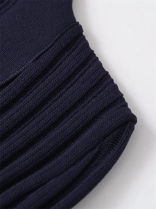 Close-up detail of dark blue ribbed knit fabric on the hem and cuffs of the dress