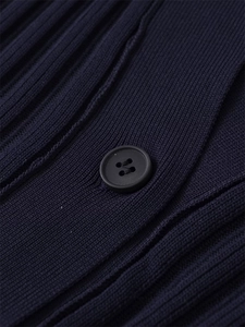 Macro shot of vertical rib-knit texture and black four-hole button on navy knit dress