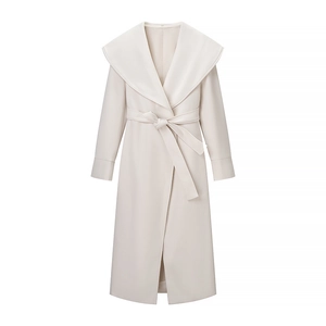 Detail of elegant cream wool coat featuring a large shawl collar and matching waist tie