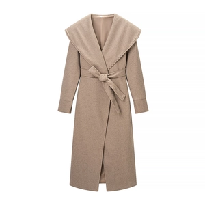 Detail view of smooth wool blend fabric and wrap belt on a camel lapel coat