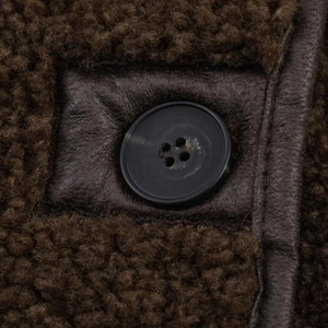 Detail of dark brown reversible jacket showing texture, faux fur, and button stitching