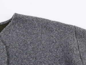 Close-up of winter sweater collar showing dark grey wool fabric and premium stitching