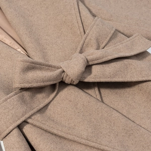 Close-up of a tied waist belt and sewing details on a camel long wool coat for women