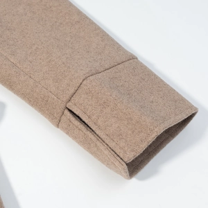 Detail view of high-quality beige wool coat sleeves with clean side slit stitching