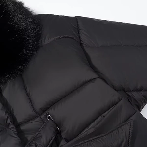 Detail of a black quilted jacket featuring a fluffy faux fur collar and metal zipper