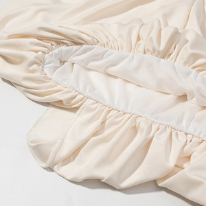 Gros plan du tissu plissé élastique blanc crème détaillant le savoir-faire du tricotage