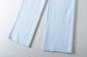 Close-up of sky blue knitted wide leg trousers showing vertical texture and hem details