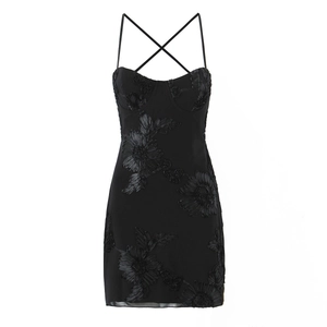 Détails d'une mini robe noire à doubles bretelles et appliques florales 3D texturées