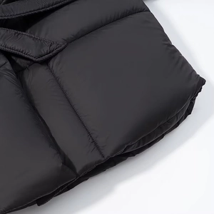 Detailed close-up of black quilted puffer jacket fabric with fine horizontal stitching