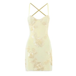 Détail d'une mini robe dos nu jaune avec broderies florales 3D et texture en maille