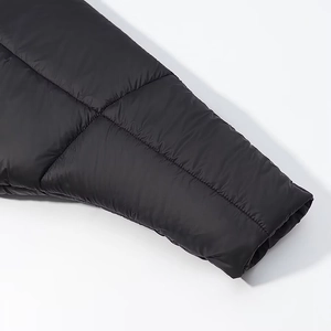 Detailed macro view of quilted black jacket sleeve with smooth ripstop nylon fabric