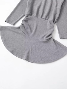 Detailed view of grey long sleeve ribbed dress with elastic waist and flared hem