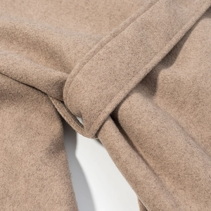 Detailed close-up of camel wool coat waist tie and high-quality fabric texture