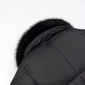 Close-up of black quilted jacket featuring plush faux fur collar and windproof fabric