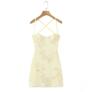 Détail d'une robe en dentelle jaune clair avec broderie florale et tulle léger