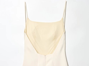 Detail shot of ivory dress with thin straps, backless cut, and hidden zipper