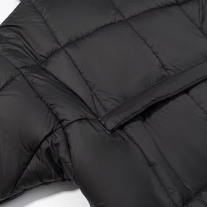 Detail view of the black quilted fabric with a flap pocket on this short puffer jacket
