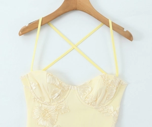 Détail de la robe bustier jaune pâle avec broderie florale 3D et fines bretelles