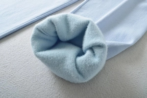 Close-up of light blue ribbed knit trousers with thick faux fur lining for winter warmth