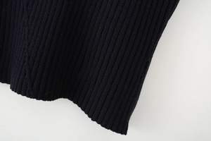 Gros plan sur la texture en maille côtelée et le tissu bleu marine du gilet femme
