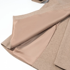 Detail view of smooth satin lining and premium wool fabric on this camel wool coat