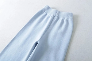 Detailed close-up of light blue high-waist ribbed waistband on thick knitted trousers