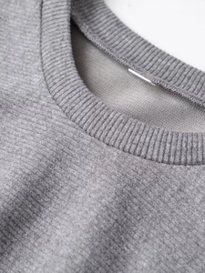 Detail of grey ribbed round neckline showing soft knitted fabric and high-quality stitching