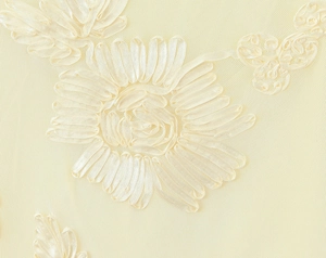 Vue macro détaillée de la broderie ruban 3D sur un tissu en maille jaune crème