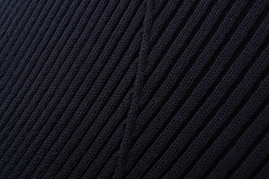 Vue macro détaillée de la texture en maille côtelée noire montrant la qualité de couture