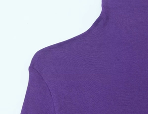 Macro detail of dark purple high neck knit sweater showing fabric texture and shoulder seam