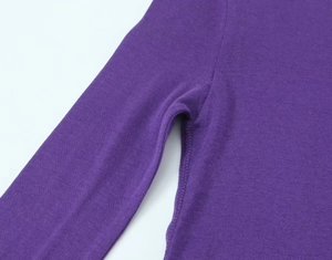 Detail view of reinforced armpit stitching on purple cotton knit long sleeve top