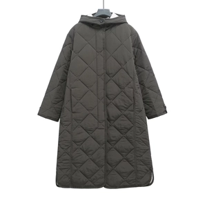 Detailed view of long quilted winter coat with diamond stitching and side slits