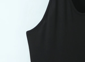 Détail du col rond et de la texture en maille côtelée d'une robe noire sans manches