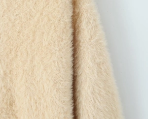 Macro texture of soft beige faux fur long plush fabric for long sleeve hooded cardigan