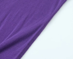 Detailed close-up of dark purple knit fabric with reinforced hem stitching and texture