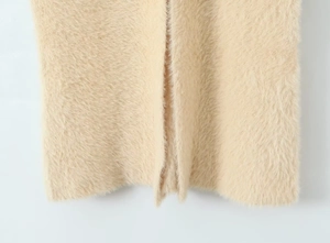 Detailed close-up of soft beige long-pile plush knit fabric with premium fluffy texture
