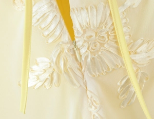 Détails de broderie marguerite et fermeture éclair sur une robe moulante jaune