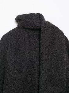 Detailed view of dark grey winter coat featuring a textured scarf and fuzzy bouclé fabric