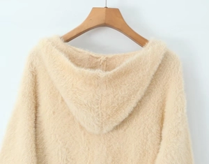 Detail view of plush beige long-hair knit fabric on hooded cardigan with soft texture