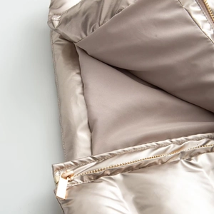 Detail of champagne gold metallic ski jacket with high-gloss waterproof fabric and zipper