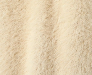 Macro view of plush cream faux fur fabric texture for hooded long sleeve cardigan coat