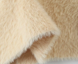 Close-up of soft beige faux fur texture on a long hooded cardigan sweater