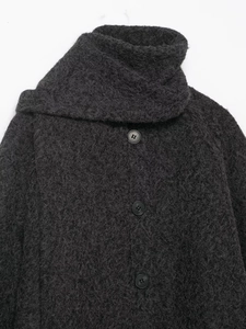 Detail of charcoal grey wool-like coat featuring fuzzy texture and black resin buttons