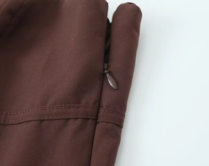 Close-up of the invisible zipper and reinforced double stitching on dark brown twill fabric