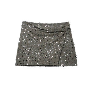 Close-up of deep grey mini wrap skirt with silver sequins and side knot detail