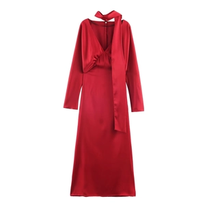Detail of red satin V-neck maxi dress showing silk texture and elegant ruching details