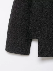 Macro shot of charcoal black plush wool texture and premium side slit detail on the coat