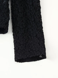 Detail shot of black lace bodysuit featuring textured bubble fabric and mesh details