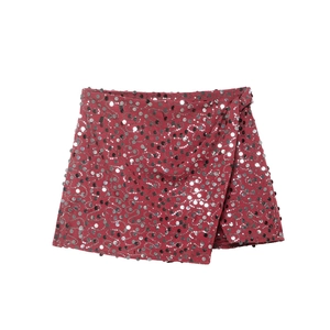 Detail view of wrap-style mini skirt featuring shimmering red and silver sequins